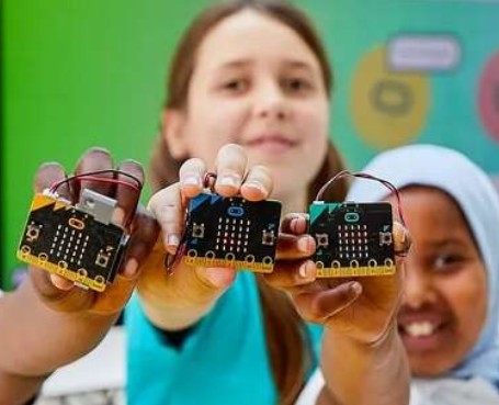 children hold out microbits to the camera