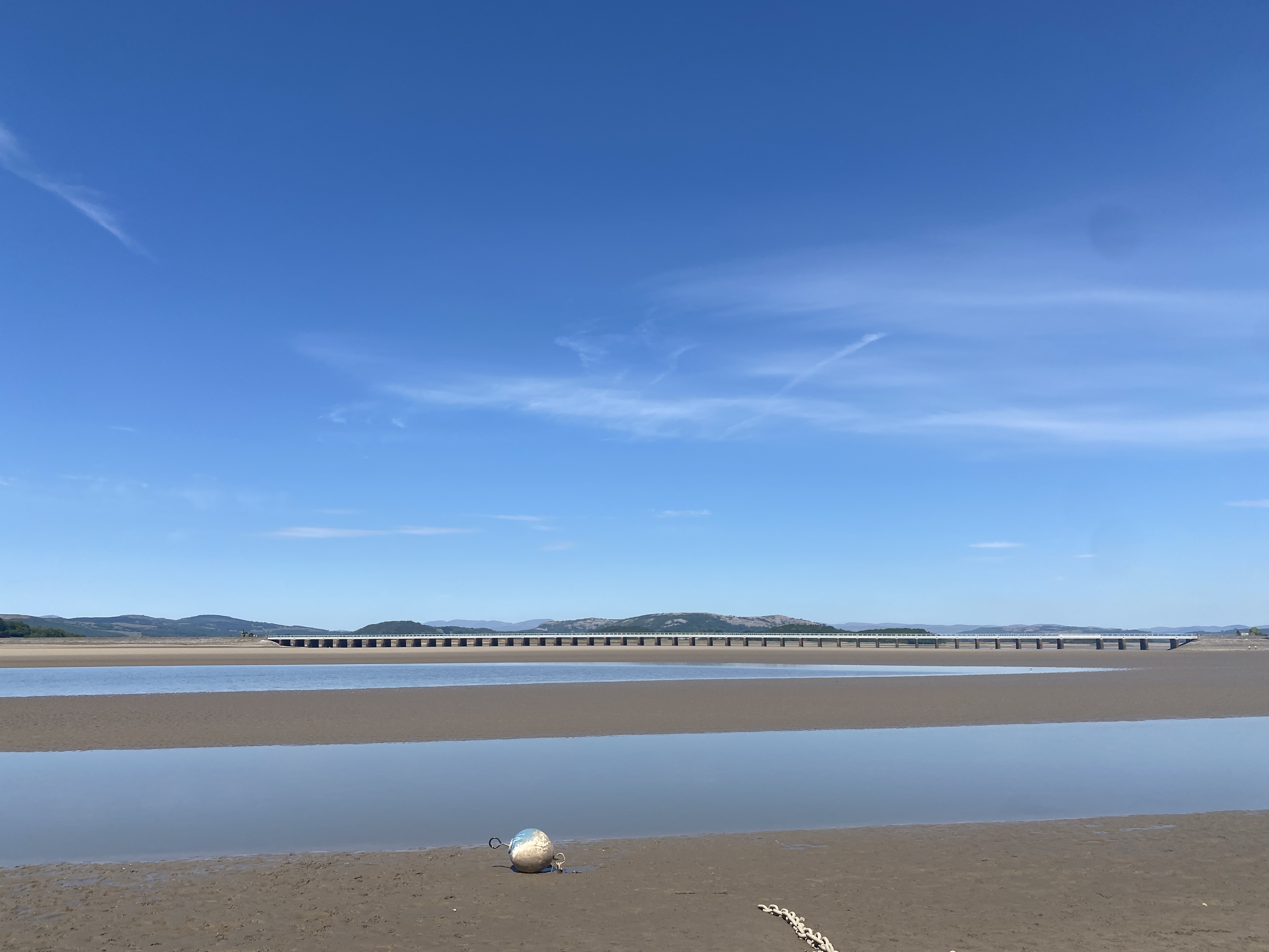 Low tide at Arnside beach with a blue sky. 