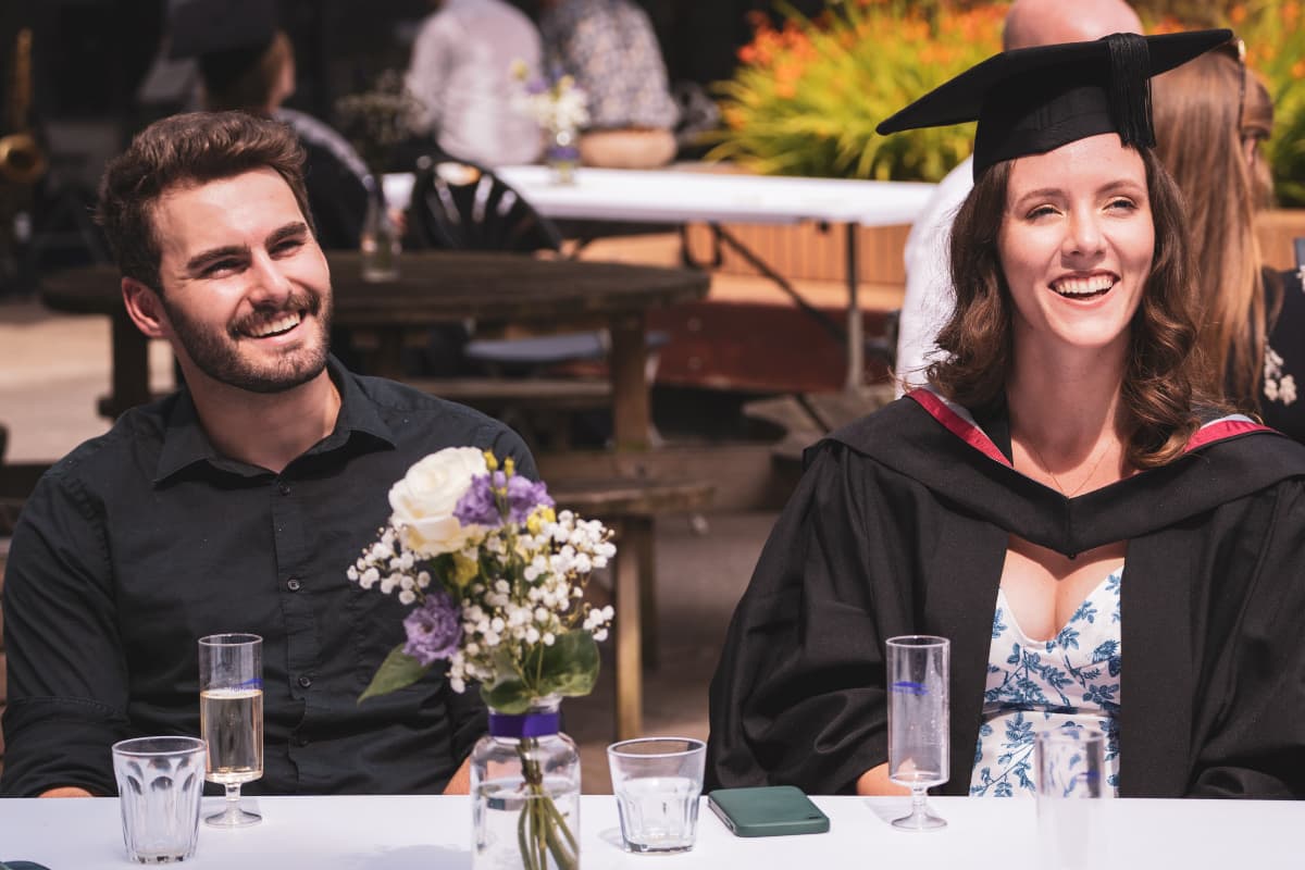 A graduate with their guest, seated at the Furness celebrations