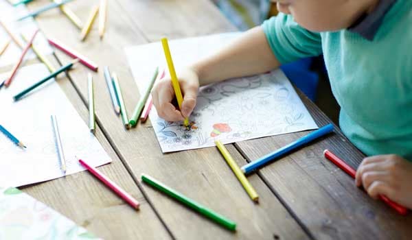 Child drawing colouring in with pencils