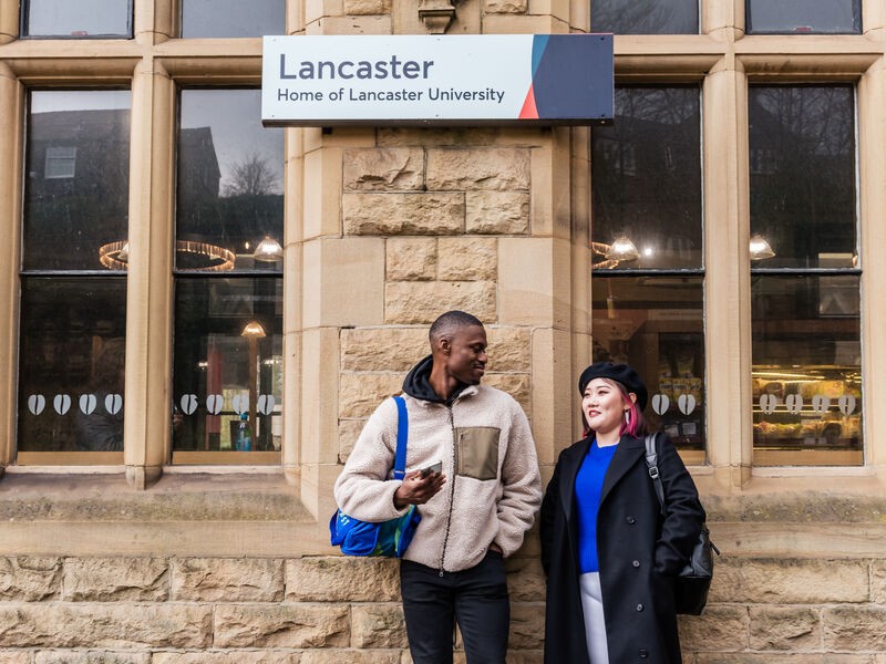 Two people are chatting while they are waiting for a train at Lancaster train station.