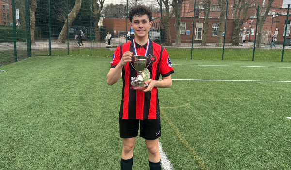 Medicine and surgery student, Ewan, holding a football trophy
