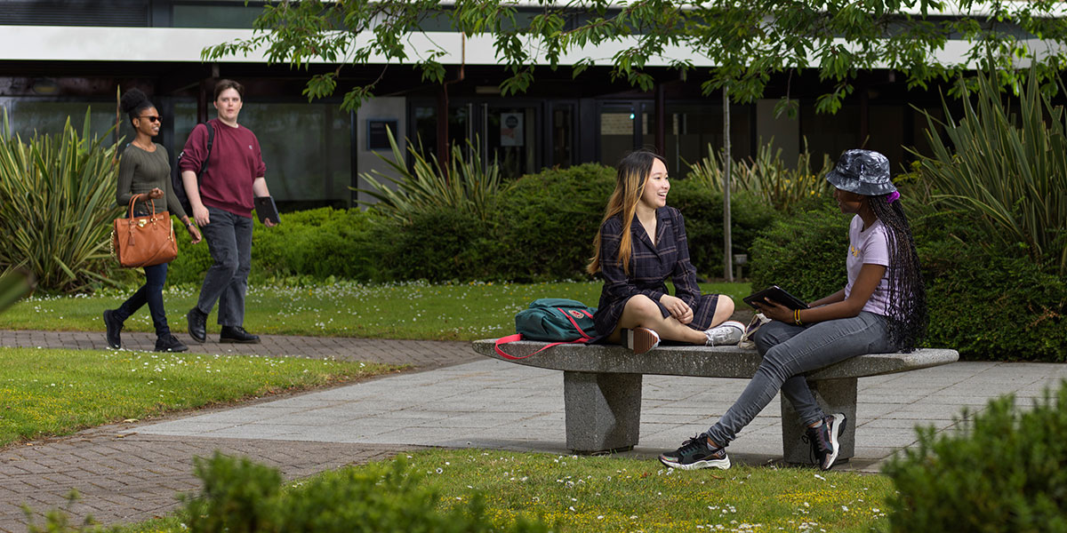 Students sitting in the sun on campus
