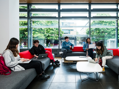 Group of four students, sitting and studying in the Learning Zone on Lancaster University campus. 