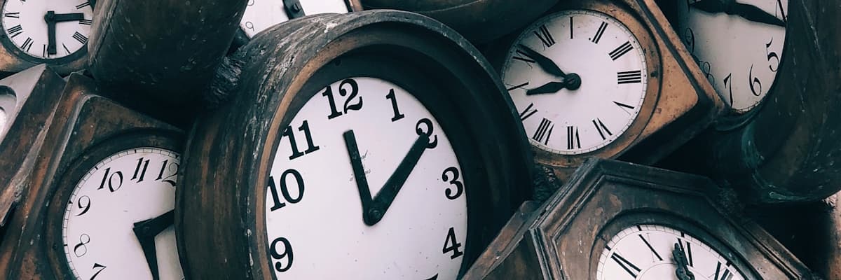 A tumbling pile of wood-framed clocks